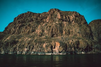Green Cliff Beside Body of Water