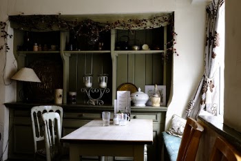Green Display Cabinet and White Dining Set in a Kitchen