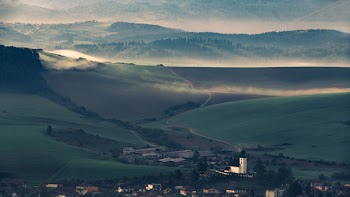 Green Grass Field Overlooking Fog Covered Mountains