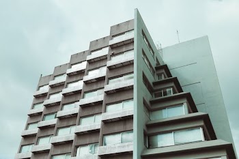 green high-rise building under the cloudy sky