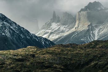 green hills near gray mountains