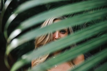 green leaf in front of smiling woman