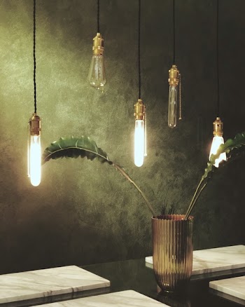 Green Leaves in Glass Vase Under Clear Bulb Pendant Lamps