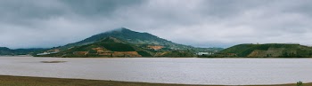 Green Mountain Beside Ocean during Cloudy Day