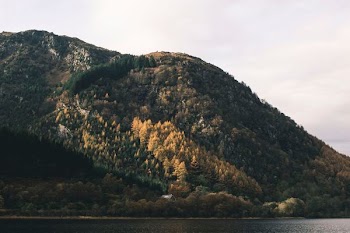 green mountain near body of water