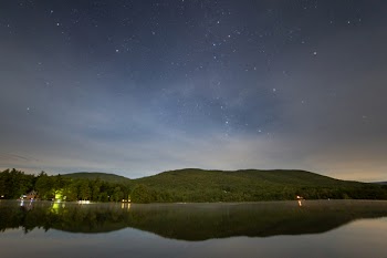 Green Mountain Near Body of Water at Night