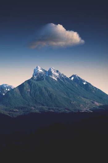 green mountain under white clouds during daytime