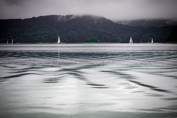 green mountains near sailboats on ocean