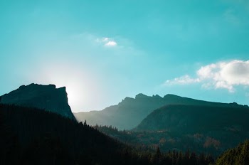 green mountains under white cloudy blue daytime sky