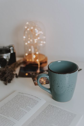 Green Mug Beside A Book