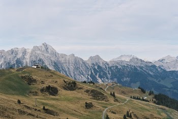 Green Open Field Viewing Mountain Under Blue and White Skie