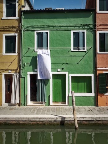 green painted building beside canal