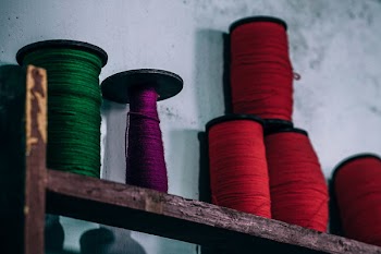 Green, Red, and Purple Yarns on Brown Wooden Rack