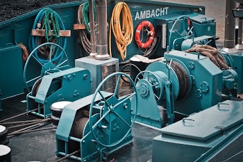 Green Ship Metal Power Tool Beside Yellow Coated Hose