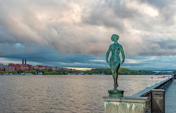 Green Statue Near Body of Water