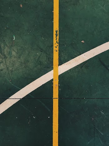 Green Surface With White and Yellow Lining Close-up Photography