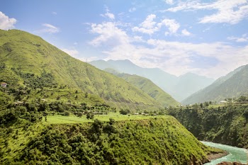 Green Valley With Wending River Under White Clouds and Blue Sky during Daytime