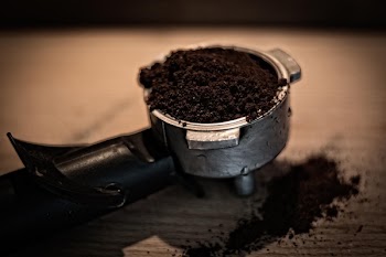 Grey and Black Coffee Cup Filled With Grind Coffee