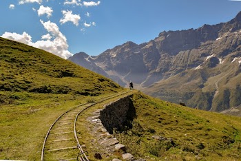 Grey Railway Near Green Grassy Hill during Cloudy Day