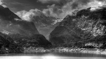 Grey Scale Photo of Body of Water Near Mountain Ranges