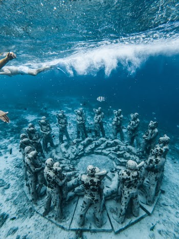 Grey Statues in Middle of Ocean