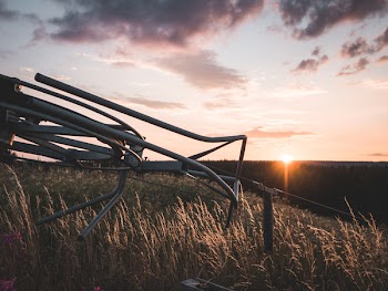 Grey Steel Farm Machine on Field during Orange Sunset