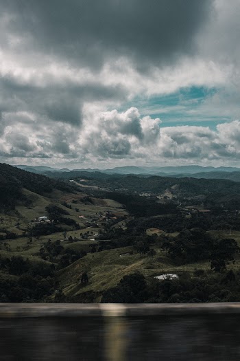 Grey Storm Clouds over Houses in Slope of Hills