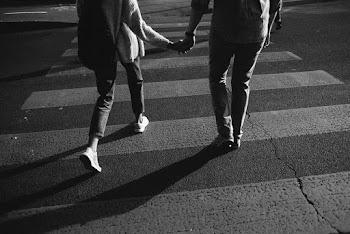 Greyscale Photo of Couple Walking Across the Road