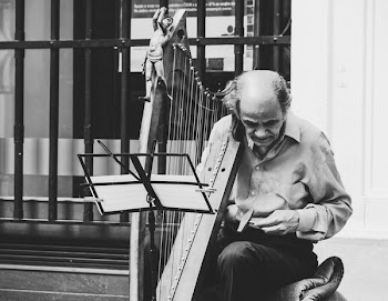 Greyscale Photo of Man Holding Harp
