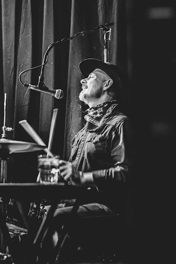 Greyscale Photo Of Man Playing Drums