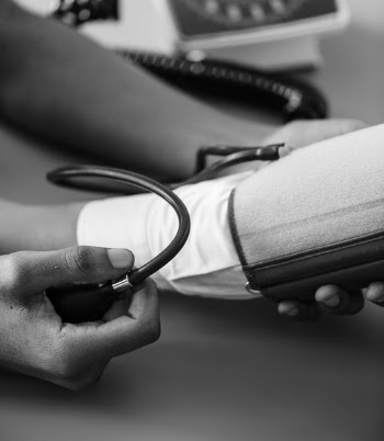 Greyscale Photo of Person Taking Blood Pressure