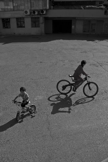 Greyscale Photo of Two Boys Riding Bicycles