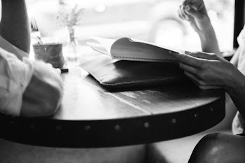 greyscale photo of two person sitting in front table