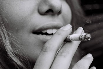 greyscale photo of woman smoking cigarette