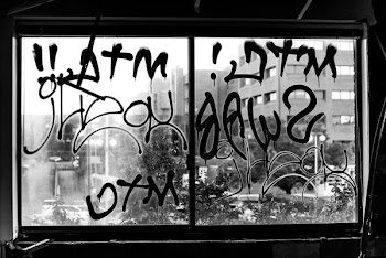 greyscale photography of glass window with graffiti