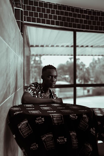 Greyscale Photography of Man Sitting Beside Table