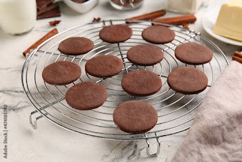 Grid with tasty chocolate cookies on white marble background