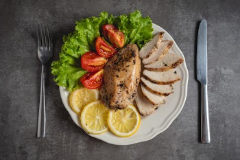 Grilled chicken on a white plate. Free Photo