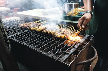 Grilling chicken satay 