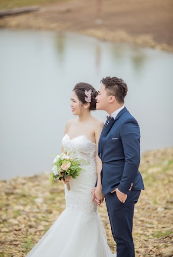 Groom and Bride Standing Near Body of Water