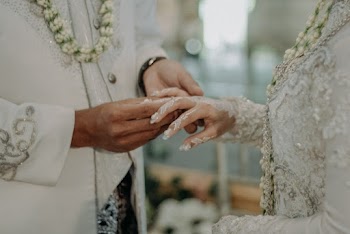 Groom Putting The Wedding Ring On The Bride's Finger