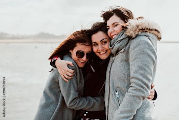 .Group of beautiful friends sharing laughs together on their trip to Porto in Portugal. Walking along the coast a windy afternoon. Lifestyle. Travel photography