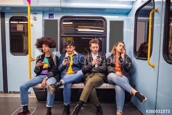 Group of friends using smartphones while traveling by metro
