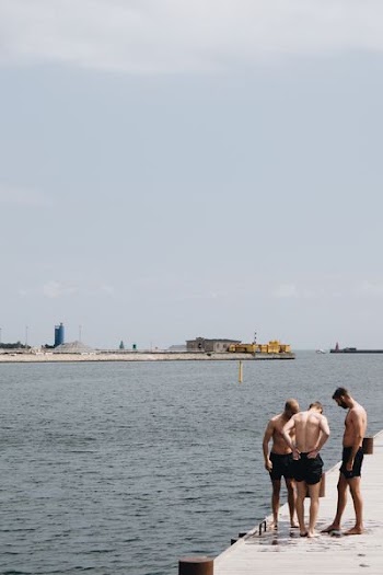 group of man standing near body of water