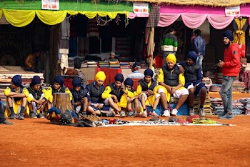 Group of Men Wearing Black and Yellow Dresses Sitting on Floor