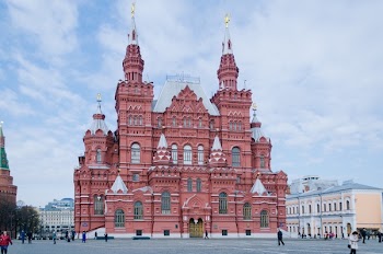 Group of People Gathered Near Red Concrete Castle
