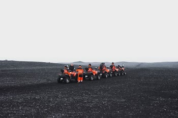 group of people in orange suit riding a ATV