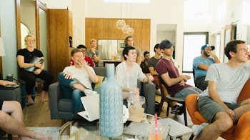Group of People Inside White and Brown House