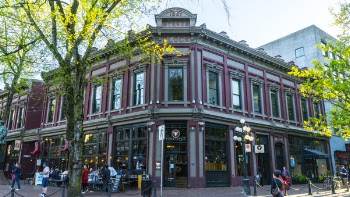 Group of People Near Gray and Pink Concrete Building