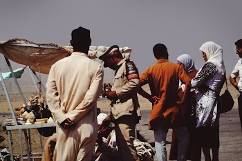 Group of People on Desert Beside Brown Tent
